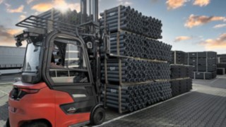 Electric counterbalanced forklift truck from Linde transporting pipes